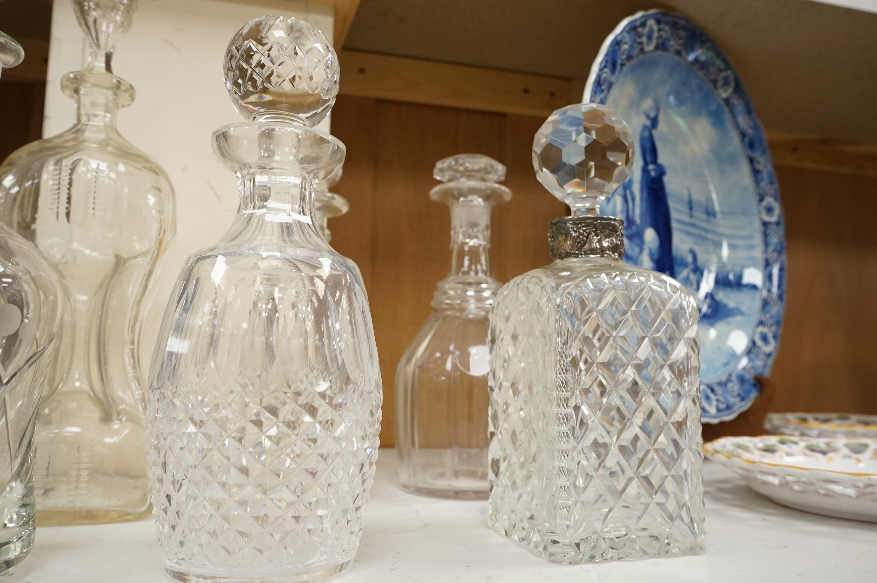Six 19th century and later cut glass decanters and stoppers, one with white metal acorn design collar, largest 37cm high